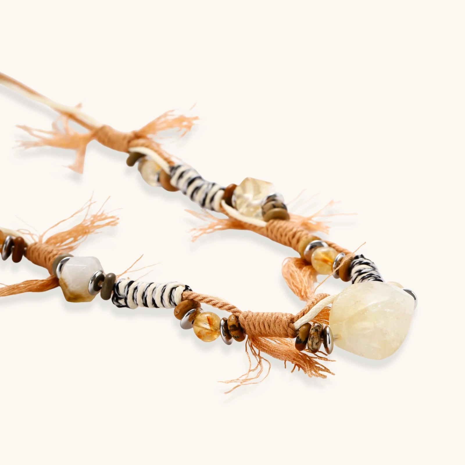 Adjustable brown cord necklace with citrine, coffee calcite beads and striped accents on white background.